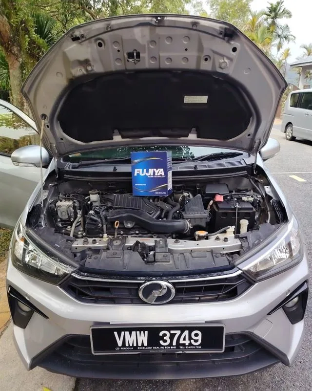Silver Perodua Bezza with the bonnet open and a Fujiya Silver battery box resting on the engine bay