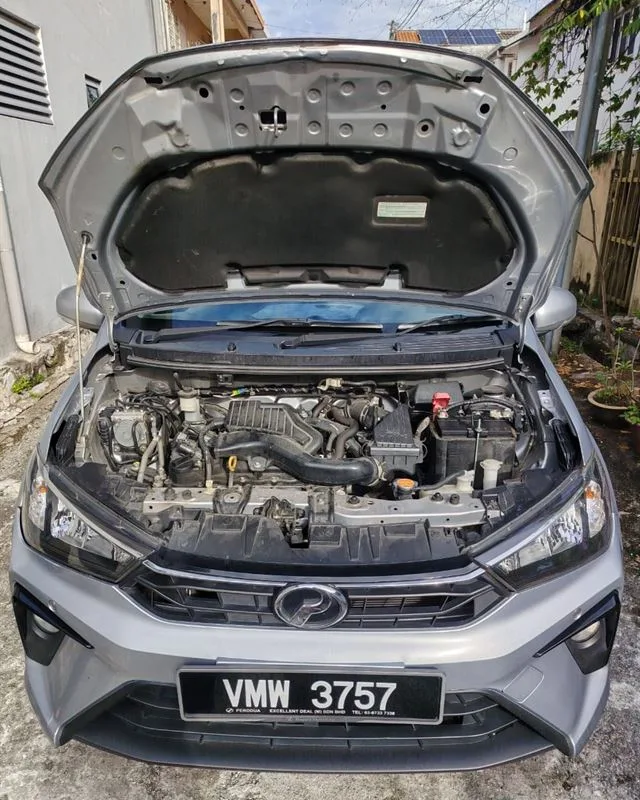 Silver Perodua Bezza with the bonnet open after an on-site battery replacement and terminal check
