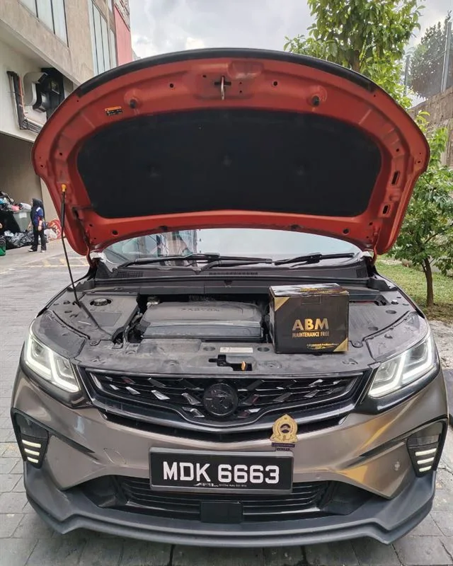 Grey Proton X50 with the bonnet open and an ABM Maintenance Free battery box on the engine bay