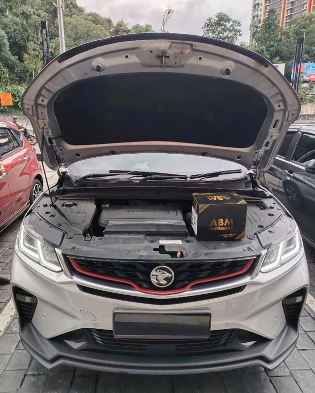 White Proton X50 with the bonnet open and a new ABM Maintenance Free battery on the engine bay